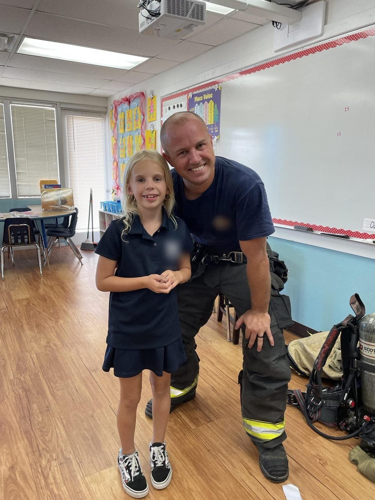 Charlie Lee in firefighting gear with his daughter Ella in her classroom
